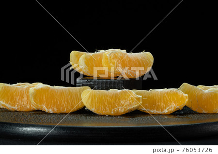 Slices of peeled orange on a black background. Slices of peeled orange on a black background. 76053726