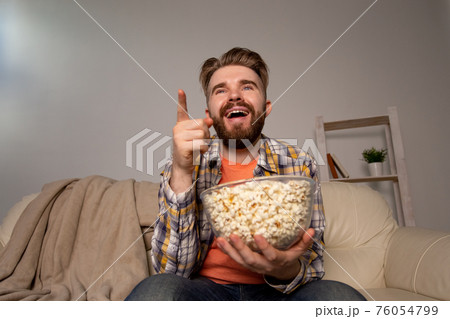 Single man on the couch watching TV 76054799