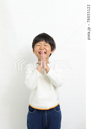 手を合わせてお願いポーズをする子供 76055122