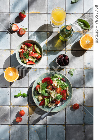 Mediterranean dishes at tiles table: vegetable and fruit salad, lemon and mint lemonade Mediterranean dishes at tiles table: vegetable and fruit salad, lemon and mint lemonade 76055769