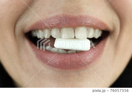 Chewing gum in a woman's teeth, close-up Chewing gum in a woman's teeth, close-up 76057356
