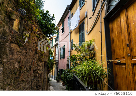 Porto Venere, Liguria, Italy. June 2020. Typical secondary alley in the heart of the town: they are called carruggio. On the right the doors of the houses overlook the narrow stone alley. 76058116