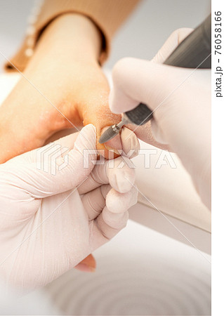 Manicurist removing old nail polish 76058166
