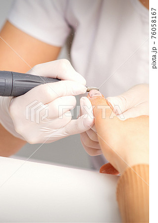 Manicurist removing old nail polish 76058167