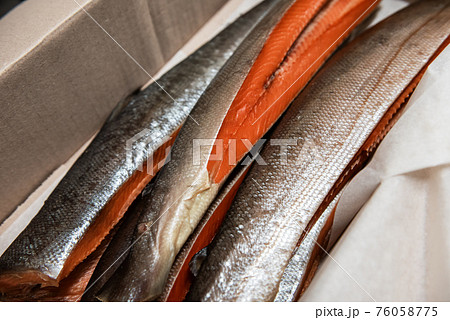Smoked fish in craft paper box. 76058775