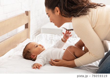 Black Mother Waking Up Her Baby Toddler After Sleep Indoor Black Mother Waking Up Her Baby Toddler After Sleep Indoor 76059319