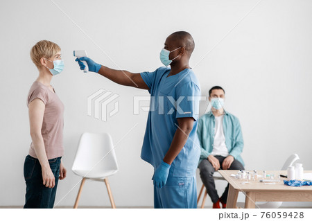 Medical staff caring for patient, check first symptoms of covid-19 virus and preparing for population vaccination 76059428