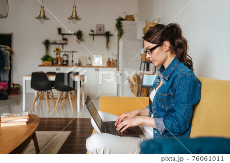Businesswoman typing an e-mail on laptop at home office. 76061011