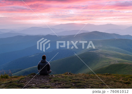 Alone tourist on the edge of the mountain hill 76061012