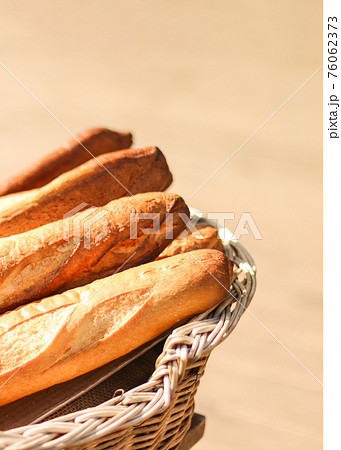 Bread baguettes in basket at baking shop on a sunny day Bread baguettes in basket at baking shop on a sunny day 76062373