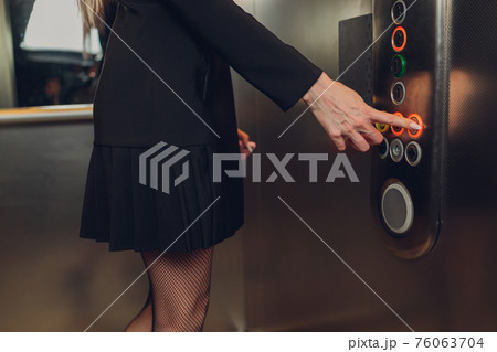 Closeup portrait of a female finger pushing elevator button. Closeup portrait of a female finger pushing elevator button. 76063704