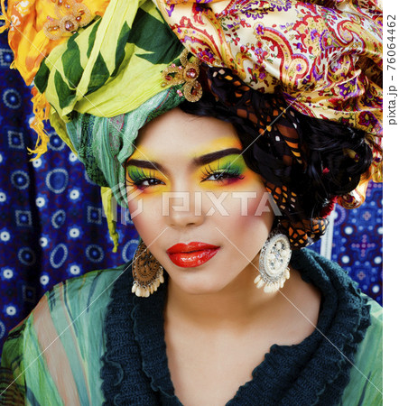 beauty bright woman with creative make up, many shawls on head like cubian, ethno look closeup 76064462