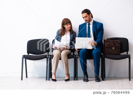 Young businessman and businesswoman waiting for an interview at Young businessman and businesswoman waiting for an interview at 76064499