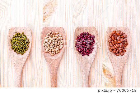 Assortment of beans and lentils in wooden spoon on wooden background.  soybean, mung bean , red bean and brown pinto beans . 76065718