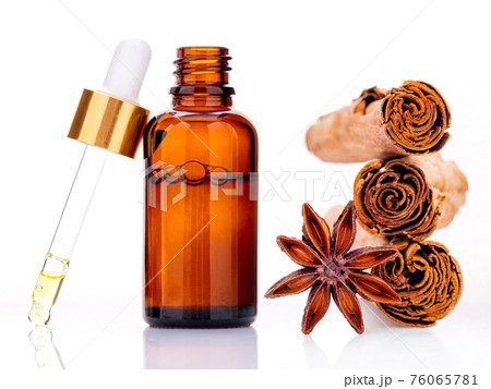 Cinnamon essential oil bottle with Ceylon cinnamon sticks and anise star isolated on white background . Cinnamon essential oil bottle with Ceylon cinnamon sticks and anise star isolated on white background . 76065781