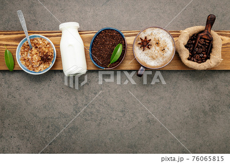 Roasted coffee beans with coffee powder and flavourful ingredients for make tasty coffee setup on dark stone background. Roasted coffee beans with coffee powder and flavourful ingredients for make tasty coffee setup on dark stone background. 76065815
