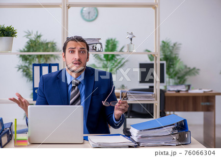 Young businessman employee unhappy with excessive work Young businessman employee unhappy with excessive work 76066304