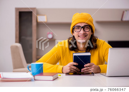Young male student preparing for exams at home 76066347