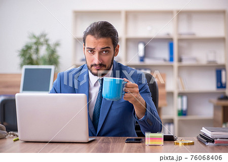 Young male employee working in the office Young male employee working in the office 76068406