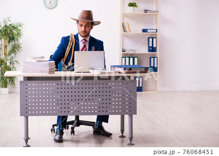 Young businessman cowboy working in the office Young businessman cowboy working in the office 76068451