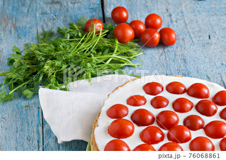 zucchini cake with tomato and parsley on a blue wooden zucchini cake with tomato and parsley on a blue wooden 76068861