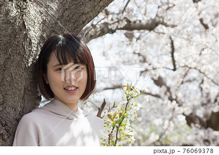 桜の木のそばで桜の枝を持って 桜の木のそばで桜の枝を持って 76069378