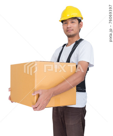 Smiling man lifts a cardboard box wearing back support belt Smiling man lifts a cardboard box wearing back support belt 76069397