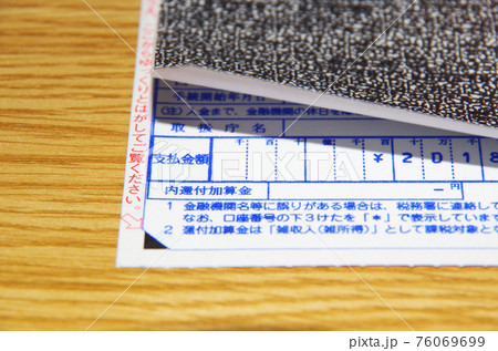 国税還付金振込通知書の表面のシールをはがして記載内容を確認しようとしている構図 国税還付金振込通知書の表面のシールをはがして記載内容を確認しようとしている構図 76069699