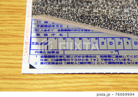 国税還付金振込通知書の表面のシールをはがして記載内容を確認しようとしている構図 国税還付金振込通知書の表面のシールをはがして記載内容を確認しようとしている構図 76069994