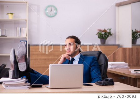 Young male employee working in the office 76070093