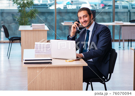 Young male employee working in the office Young male employee working in the office 76070094