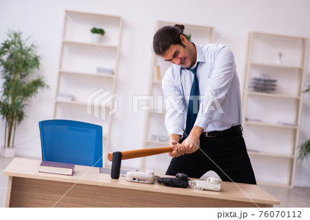 Young male call center operator working at his desk 76070112