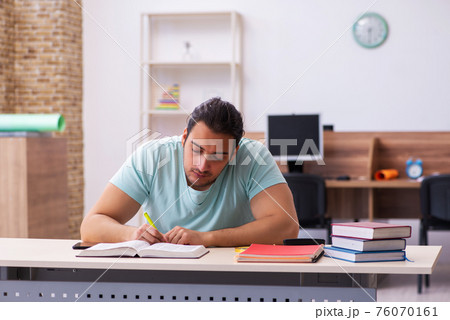 Young male student preparing for exam at home 76070161