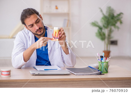 Young male odontologist working in the clinic 76070910