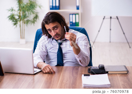 Drug addicted male employee working in the office 76070978