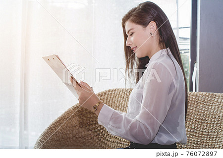 Business woman in white uniform reading report the commercial processes involved in promoting and selling and distributing Business woman in white uniform reading report the commercial processes involved in promoting and selling and distributing 76072897