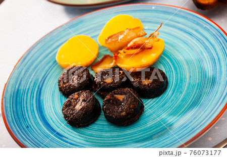 Fried blood sausage with potatoes served at plate 76073177