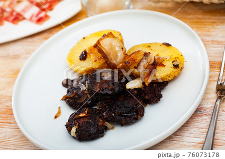 Catalan blood sausage with garnish of baked potatoes 76073178