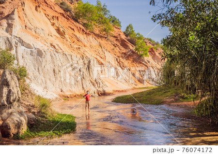 Boy tourist on the Fairy stream among the red dunes, Muine, Vietnam. Vietnam opens borders after quarantine COVID 19 76074172