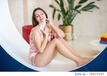 Young woman in pink lingerie and tapes on her neck looking relaxed Young woman in pink lingerie and tapes on her neck looking relaxed 76075287