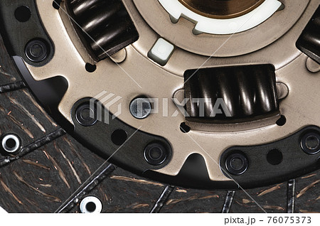 Clutch disc of a manual transmission of a passenger car on a gray background. Close-up detail view 76075373