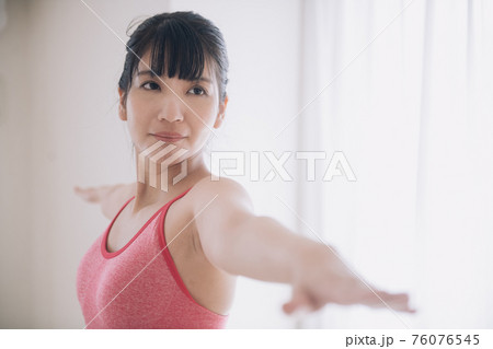 ヨガをする女性（英雄のポーズ） 76076545