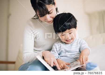 絵本を読む母親と男の子　読み聞かせ・子育て・育児イメージ 76076635