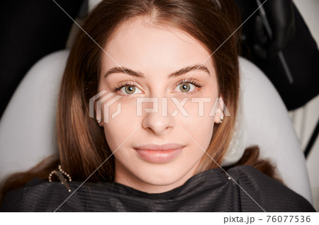 Attractive young woman lying in dental chair. 76077536