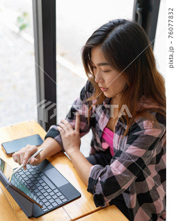 Top view of female freelancer working with digital tablet on the table in cafe 76077832