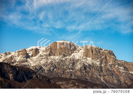 Snow Capped Mountain Range of the Paganella in Winter - Alps Trentino Italy Snow Capped Mountain Range of the Paganella in Winter - Alps Trentino Italy 76079108