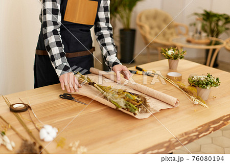 Florist woman makes bouquet of dried flowers Florist woman makes bouquet of dried flowers 76080194