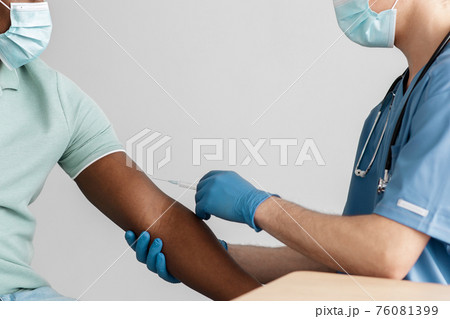 Hand of medical worker injecting coronavirus covid-19 vaccine 76081399
