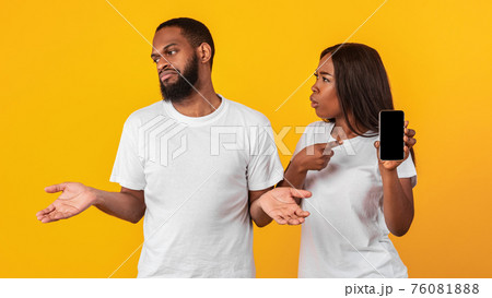 Black woman checking her boyfriend mobile phone Black woman checking her boyfriend mobile phone 76081888
