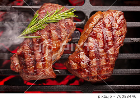 Beef steaks cooking on grill 76083446